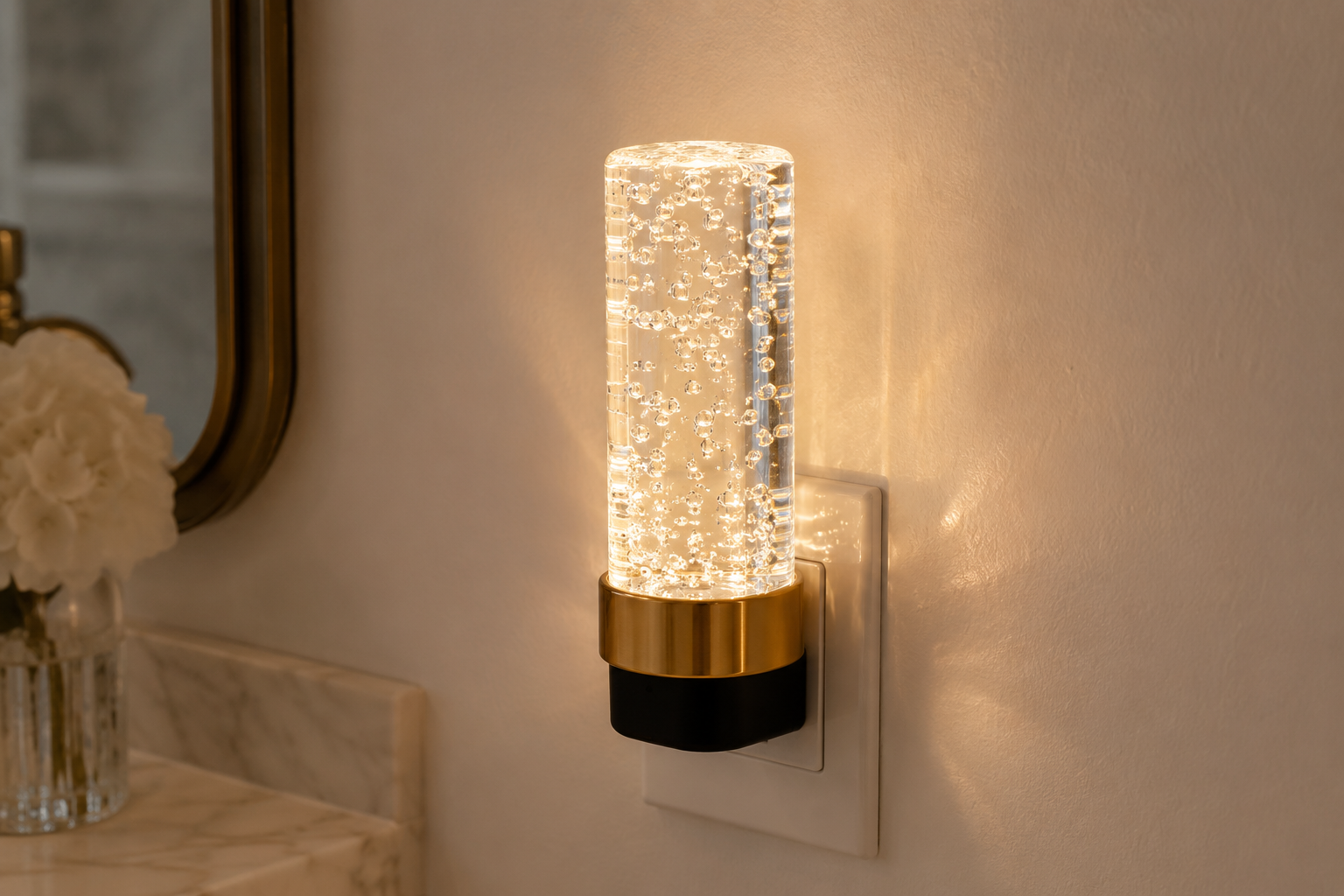 Decorative acrylic crystal plug-in night light with brushed gold ring glowing warm white
